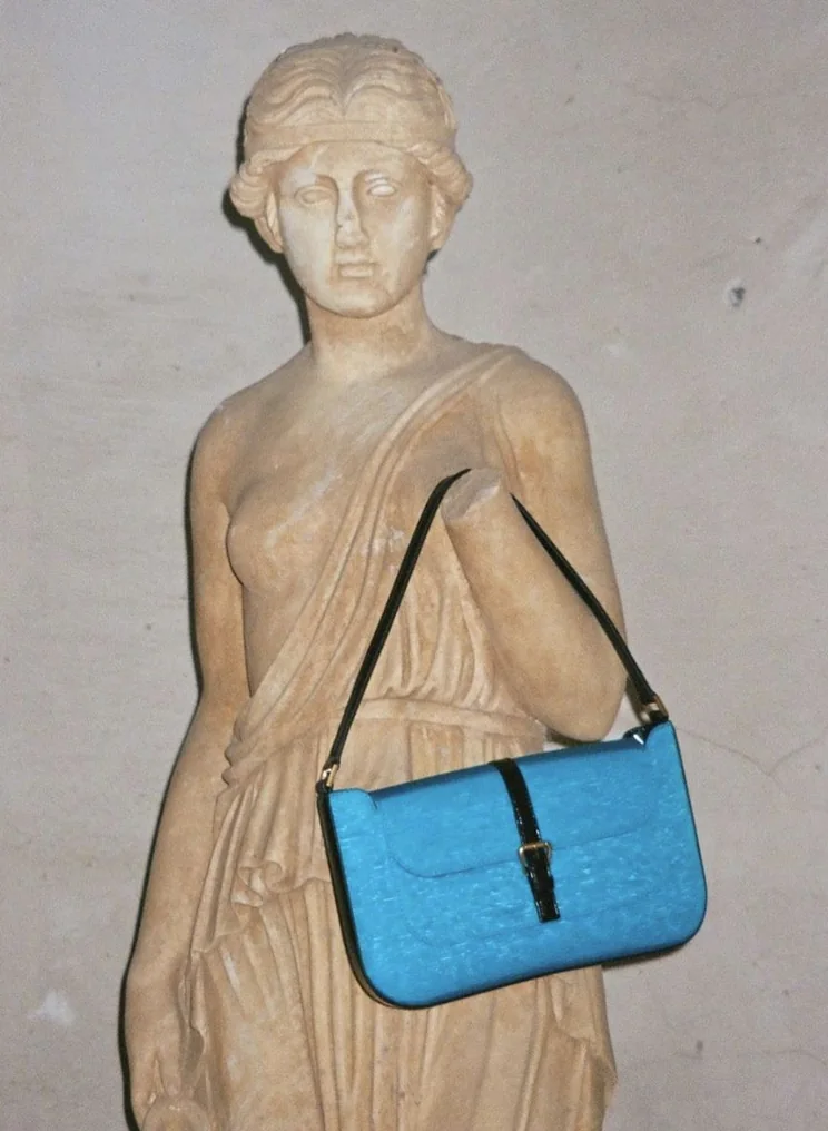Blue shoulder bag hung on a plaster statue